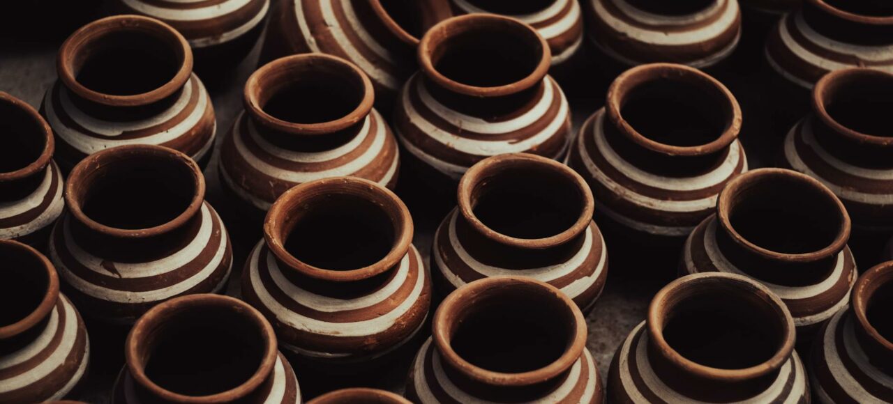 a group of brown clay pots with white stripes