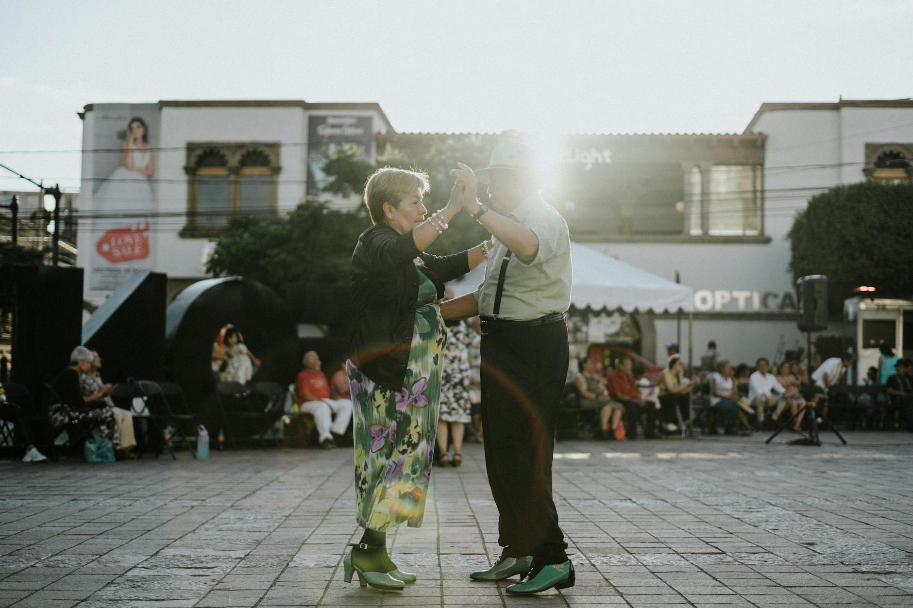 man and woman dancing on square at sunset